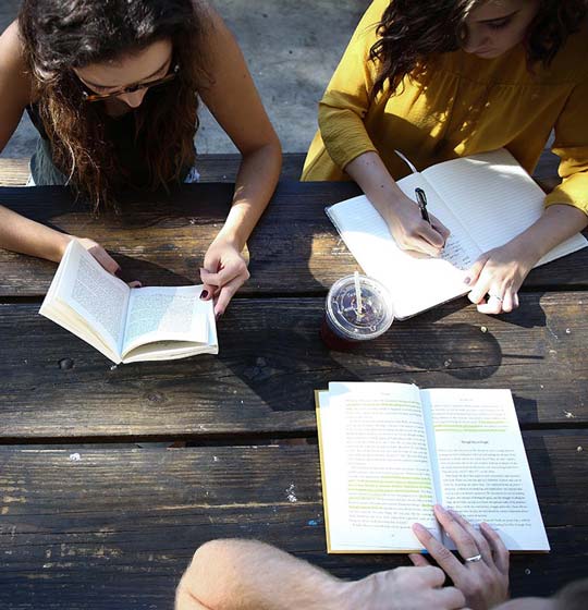 Girls sitting around a table and writing